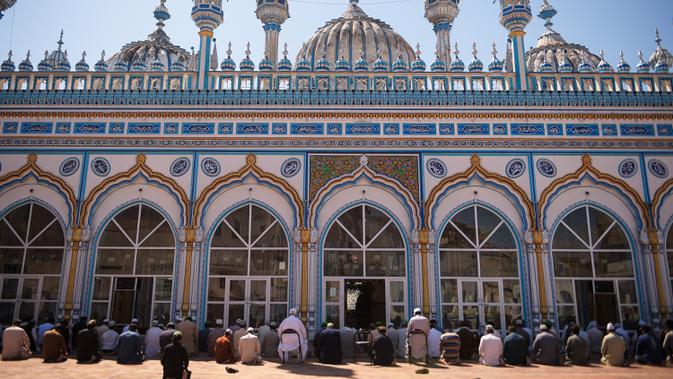 Umat Muslim berdoa di sebuah masjid sambil menjaga jarak sosial selama penguncian nasional yang diberlakukan pemerintah sebagai tindakan pencegahan terhadap coronavirus COVID-19, di Rawalpindi, Pakistan (19/4/2020). (AFP/Farooq Naeem)
