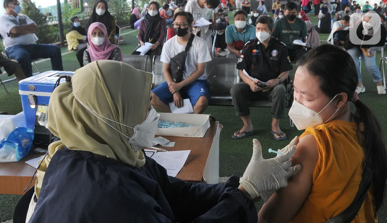 Vaksinator menyuntikkan vaksin dosis ketiga kepada seorang perempuan di kolong flyover Ciputat, Tangerang Selatan, Sabtu (2/4/2022). Selain untuk melengkapi vaksin COVID-19, booster menjadi syarat perjalanan mudik lebaran tahun 2022. (merdeka.com/Arie Basuki)