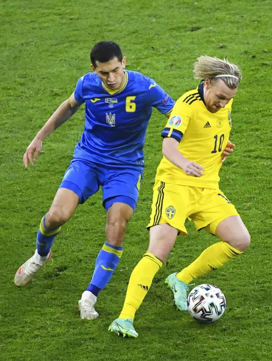 Pemain Swedia Emil Forsberg (kanan) dan memperebutkan bola dengan pemain Ukraina Taras Stepanenko pada pertandingan babak 16 besar Euro 2020 di Stadion Hampden Park, Glasgow, Selasa (29/6/2021). Ukraina menang 2-1. (AP Photo/Andy Buchanan, Pool)