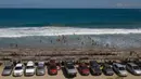 Mobil wisatawan diparkir di sepanjang pantai Los Angeles yang baru-baru ini dibuka kembali di La Guaira, Venezuela, Jumat (23/10/2020). Pemberlakuan lockdown yang ketat akibat COVID-19 memaksa penutupan pantai di seluruh negeri pada Maret lalu dan dibuka kembali minggu ini. (AP/Matias Delacroix)