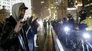 Pengunjuk rasa menghadapi polisi saat aksi protes di Chicago, Illinois, Rabu (25/11). Ketegangan rasial memanas setelah rilisnya video seorang polisi kulit putih menembak remaja kulit hitam, Laquan McDonald (17) pada Oktober 2014. (REUTERS/Andrew Nelles)