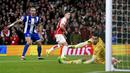 Pemain Arsenal, Leandro Trossard (tengah) mencetak gol ke gawang Porto pada laga leg kedua 16 besar Liga Champions 2023/2024 di Emirates Stadium, London, Inggris, Rabu (13/03/2024) dini hari WIB. (AP Photo/Zac Goodwin)