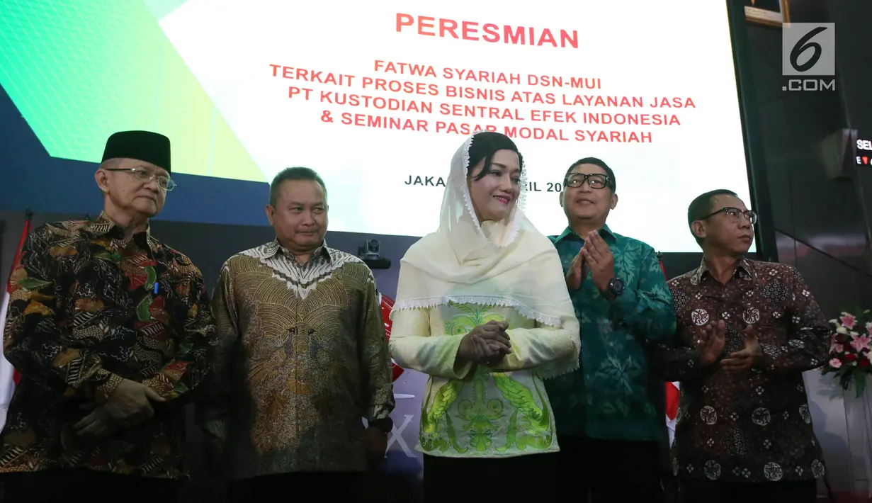 Sekretaris DSN-MUI, Anwar Abbas (kiri) dan Direktur Utama PT Kustodian Sentral Efek Indonesia (KSEI), Friderica Widyasari Dewi (tengah) saat penyerahan fatwa syariah terkait proses Bisnis Atas Layanan Jasa di Gedung Bursa Efek Indonesia, Jakarta, Senin (1/4). (Liputan6.com/Johan Tallo)