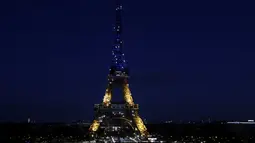 Menara Eiffel mendapat penerangan dengan warna bendera Ukraina di Paris (25/2/2022). Pasukan Rusia menyerang ibu kota Ukraina pada Jumat (25/2) dengan tembakan dan ledakan dalam invasi ke negara demokratis yang memicu kekhawatiran perang yang lebih luas di Eropa. (AP Photo/Adrienne Surprenant)