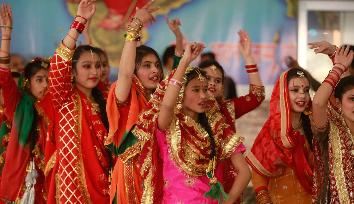 Gadis-gadis India berpakaian tradisional menari saat mereka merayakan festival Lohri di Jammu, India (13/1). Beberapa orang percaya bahwa perayaan tersebut untuk memperingati terjadinya titik balik musim dingin. (AP Photo / Channi Anand)