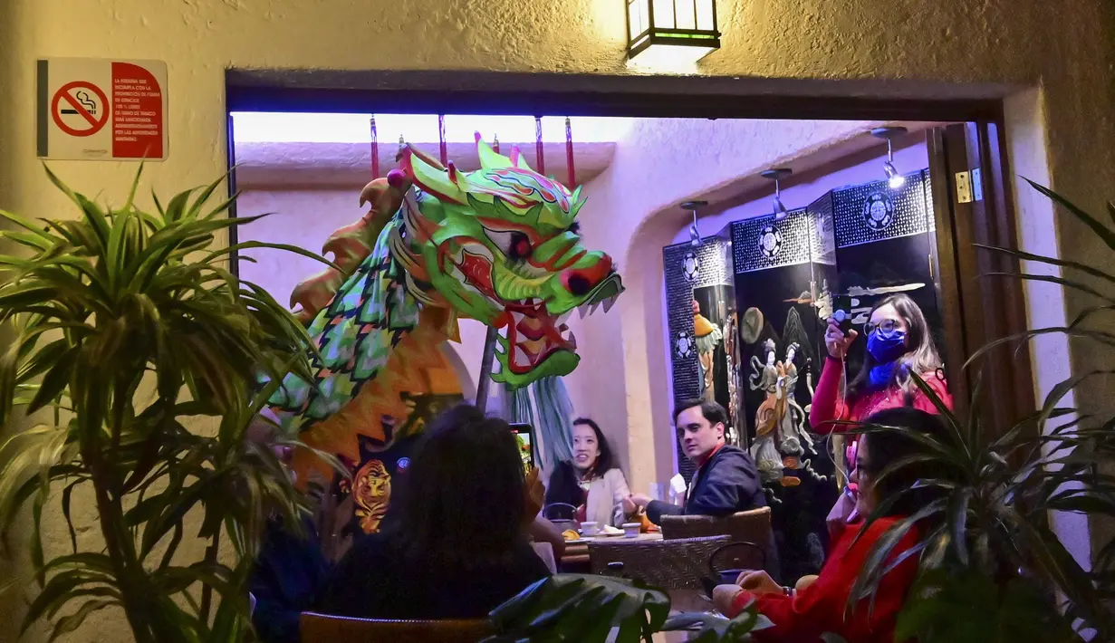 Anggota komunitas Tionghoa di Meksiko menampilkan tarian naga tradisional (liong) di sebuah restoran Tiongkok menyambut Tahun Baru Imlek di Mexico City, pada 31 Januari 2022. Tahun Baru Imlek 2022 menandai dimulainya tahun Shio Macan Air. (PEDRO PARDO / AFP)