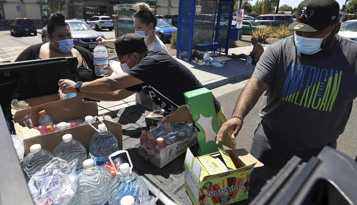 Masyarakat membagikan air, es, es loli, dan Gatorade kepada individu yang mengalami tunawisma saat suhu mencapai 112 derajat di Santa Rosa, California, Senin, 5 September 2022. (Kent Porter/The Press Demokrat via AP)
