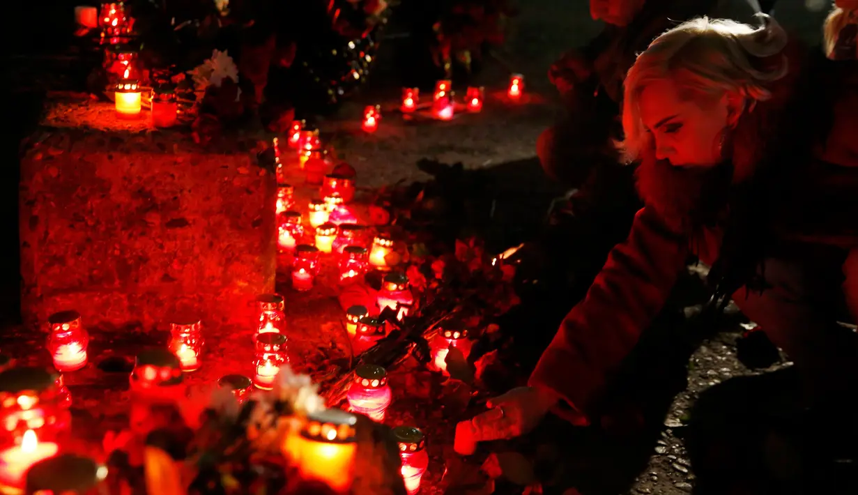 Warga di Sochi, Rusia menyalakan lilin sebagai ungkapan berkabung atas tragedi jatuhnya pesawat militer Rusia Tupolev Tu-154 di Laut Hitam, Rusia, Minggu (25/12). (REUTERS / Maxim Shemetov)
