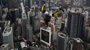 Penerjun Amerika Serikat Sean Devlin (kanan) melompat dari dek terbuka Menara Kuala Lumpur saat International Tower Jump, Kuala Lumpur, Malaysia, 3 Februari 2023. Lebih dari 100 penerjun melompat dari Menara Kuala Lumpur setinggi 300 meter yang terkenal tersebut. (MOHD RASFAN/AFP)