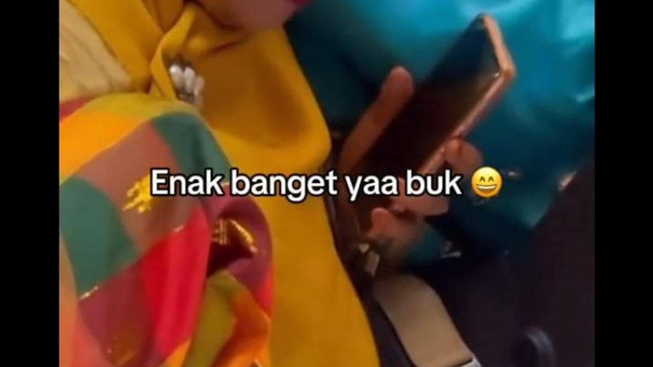 Ibu ini juga terlihat bisa membagi perhatiannya untuk makan, menonton Krisdayanti bernyanyi, sambil memegang <i>handphone</i> untuk merekam.