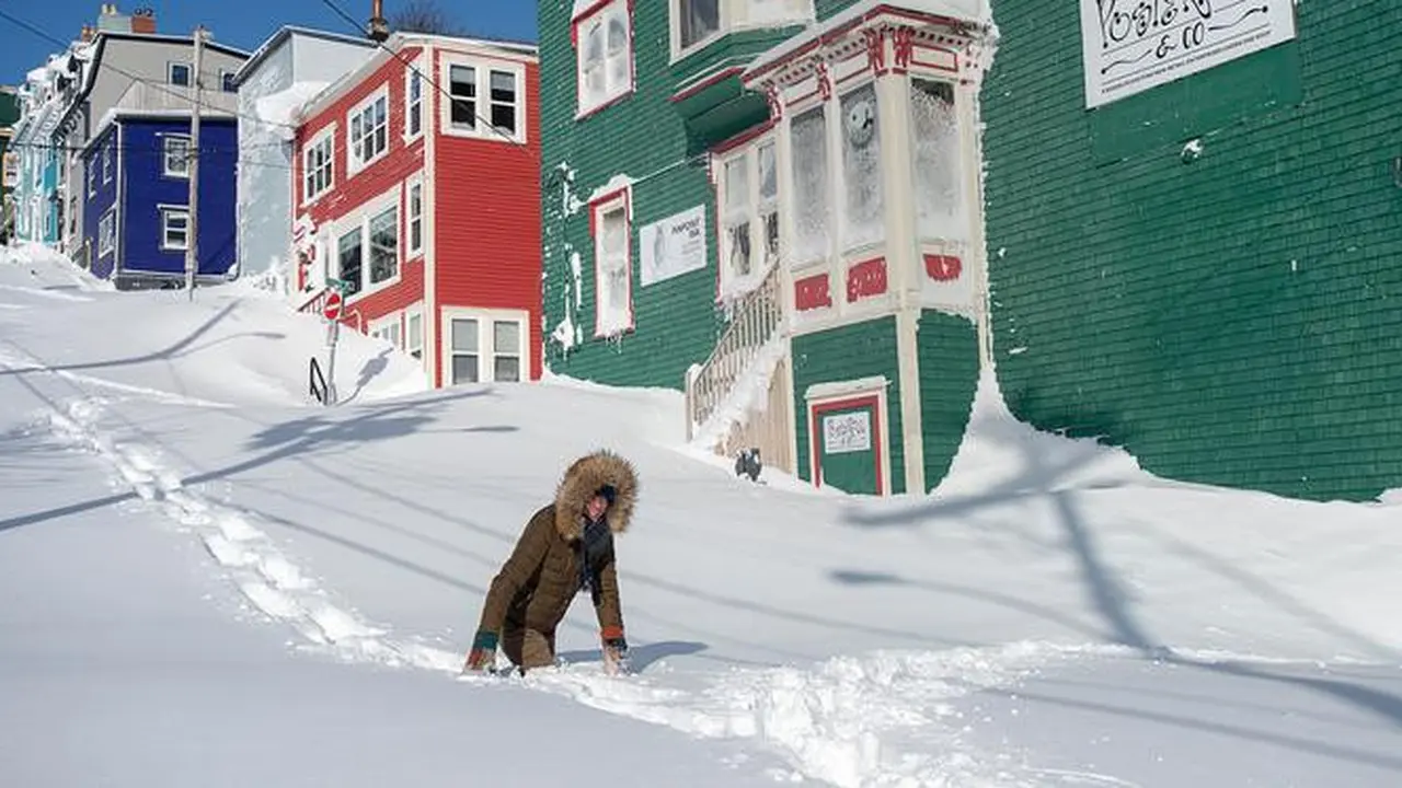 Warga berjalan melewati salju di Kota St John's, Newfoundland, Kanada, Sabtu (18/1/2020).