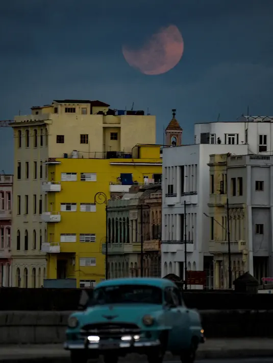 Bulan Purnama Super Pink muncul di atas langit Havana, Kuba pada Senin (26/4/2021). Super Pink Moon merupakan fenomena alam ketika posisi bulan purnama berada terdekat dengan bumi. (Photo by YAMIL LAGE / AFP)