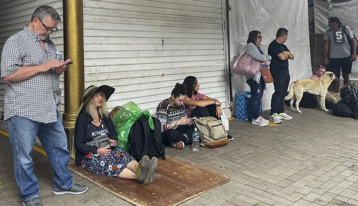 Turis menunggu di luar stasiun kereta Machu Picchu setelah layanan kereta api dihentikan karena kerusakan yang diduga disebabkan oleh pengunjuk rasa di Machu Picchu, Peru, Sabtu (21/1/2023). Demonstrasi itu menentang dimakzulkan mantan Presiden Peru Pedro Castillo, dan menentang Presiden saat ini, Dina Boluarte. (Photo by Carolina Paucar / AFP)