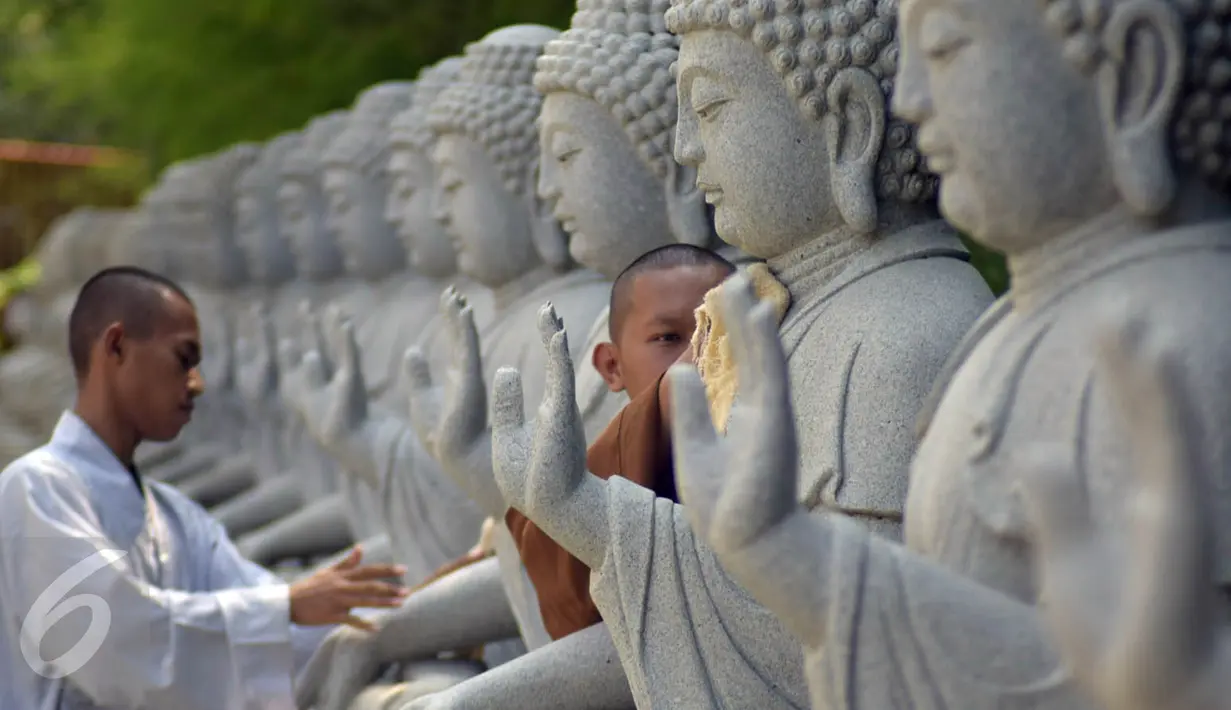 Dua orang bhiksu membersihkan patung di  Vihara Mahavira Graha Semarang , Sabtu ( 21/5/2016). Terdapat 120 patung Budha di Vihara Mahavira Graha Semarang. (Gholib)