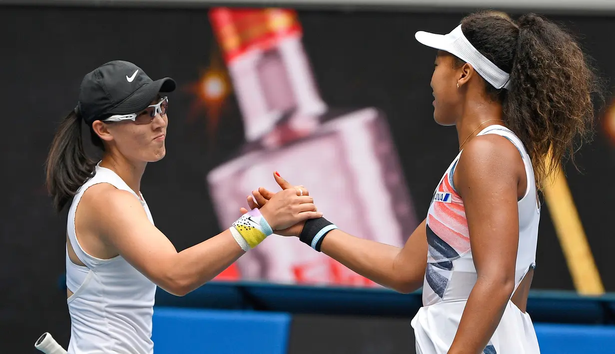 Petenis Jepang Naomi Osaka (kanan) bersalaman dengan petenis China Zheng Saisai usai memenangkan pertandingan tunggal putri putaran kedua di Australia Terbuka, Melbourne, Australia, Rabu (22/1/2020). Naomi mengalahkan Saisai dan melaju ke putaran ketiga Australia Terbuka. (AP Photo/Andy Brownbill)