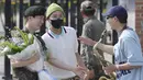 RM memainkan lagu “Dynamite” dengan saksofon, sementara Jin tersenyum lebar melihat aksi sahabatnya.  (Im Byung-shik/Yonhap via AP)