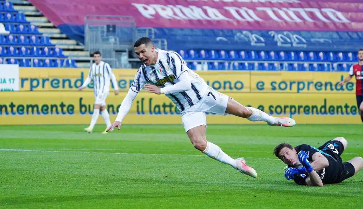 Striker Juventus, Cristiano Ronaldo, terjatuh saat berusaha melewati kiper Cagliari, Alessio Cragno, pada laga Liga Italia di Sardegna Arena, Minggu (14/3/2021). Juventus menang dengan skor 3-1. (Alessandro Tocco/LaPresse via AP)