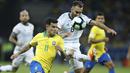 Gelandang Brasil, Philippe Coutinho, berebut bola dengan pemain Argentina, German Pezzella, pada laga Copa America 2019 di Stadion Mineirao, Rabu (3/7). Brasil menang 2-0 atas Argentina. (AP/Victor R. Caivano)
