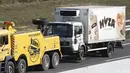 Sebuah truk yang berisi sekitar 50 imigran gelap yang tewas siap diderek dari jalan tol di Austria, dekat perbatasan Hongaria, Kamis (27/8/2015). Indikasi awal mereka tewas karena kekurangan oksigen. (AFP PHOTO/Dieter NAGL)