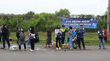 Sejumlah pemudik menunggu kedatangan bus di Simpang Cikopo, Jawa Barat, Sabtu (30/4/2022). Memasuki H-2 Hari Raya idul Fitri 1443 Hijriah terpantau masih ramai para pemudik jurusan Jawa Tegah dan Jawa Barat yang naik melalui simpang Cikopo tersebut. (Liputan6.com/Herman Zakharia