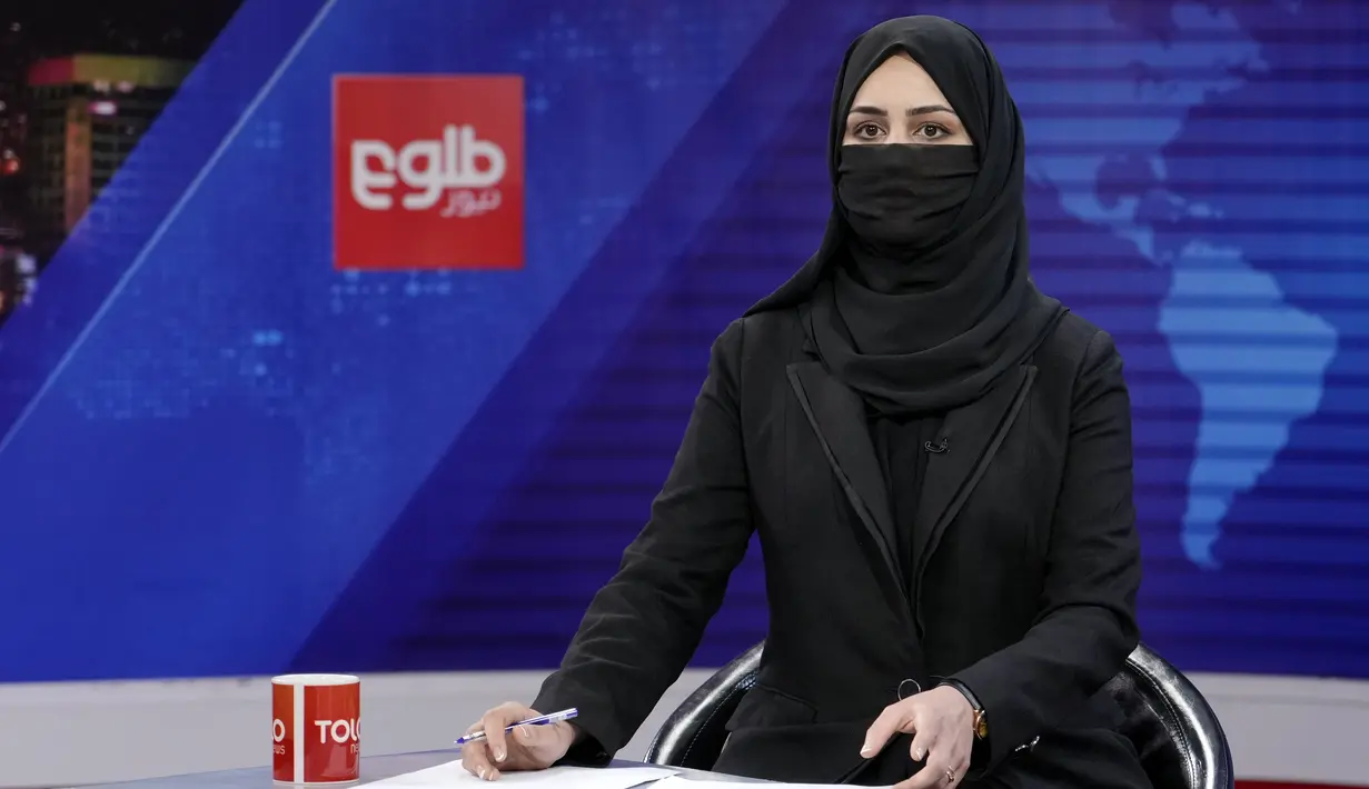 <p>Khatereh Ahmadi, seorang presenter televisi mengenakan penutup wajah saat membacakan berita di TOLO NEWS, di Kabul, Afghanistan, Minggu, 22 Mei 2022. Taliban mulai mewajibkan semua presenter atau pembawa acara televisi perempuan menutupi wajah mereka saat siaran. (AP Photo/Ebrahim Noroozi)</p>