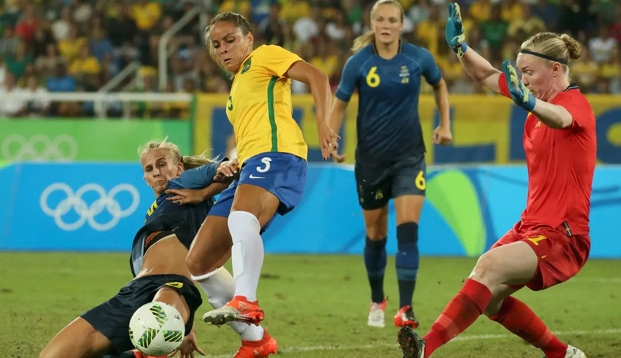 Pemain Brasil Thaisa (tengah) saat melewati hadangan pemain Swedia pada lanjutan sepak bola wanita di Olimpiade Rio 2016,Brasil, (6/8). Empat puluh tiga ribu suporter bergemuruh saat kesebelasan Brasil menang telak. (REUTERS / Gonzalo Fuentes)