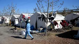 Seorang wanita berjalan di sebuah kamp untuk pengungsi Suriah di Turki yang didirikan oleh lembaga bantuan Turki AFAD di distrik Islahiye, Gaziantep, Rabu (15/2/2023). Gempa berkekuatan 7,8 magnitudo yang melanda Turki dan Suriah pada Senin (6/2) kemungkinan akan menjadi salah satu bencana yang paling mematikan dalam dekade ini, ungkap para seismolog. (OZAN KOSE/AFP)