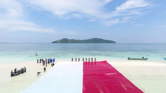 Lagu Kebangsaan Indonesia Raya dari Kapal Angkatan Laut (KAL) Tedung Selar II.8.25 serta penghormatan umum mengiringi pembentangan bendera tersebut.