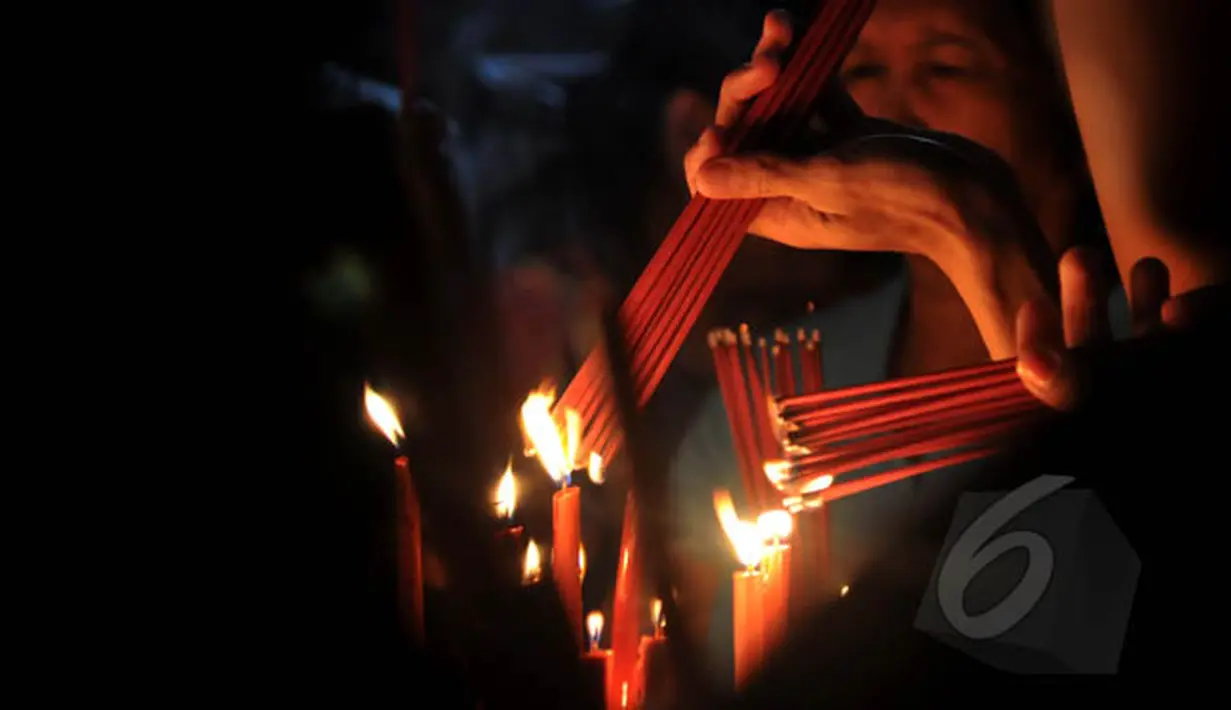 Warga etnis Tionghoa menyalakan hio untuk berdoa, pada malam Tahun Baru Imlek 2566 di Klenteng Boen Tek Bio di Pasar Lama, Tangerang, Rabu (18/2/2015) malam. (Liputan6.com/Johan Tallo)