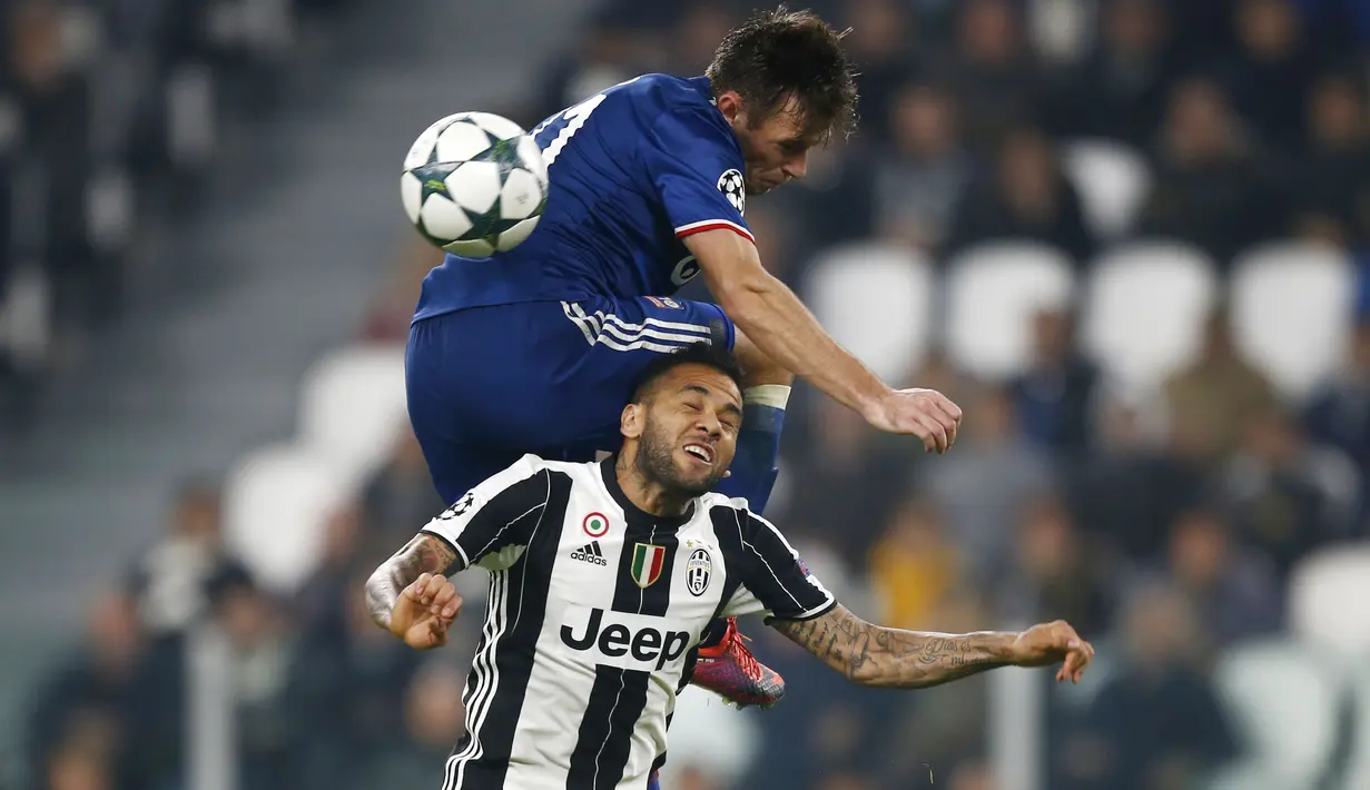 Bek Juventus, Daniel Alves (bawah) berusaha menjangkau bola saat duel dengan pemain Lyon, Maciej Rybus pada laga grup H Liga Champions di Juventus stadium, Turin, (2/11/2016). (AFP/Marco Bertorello)