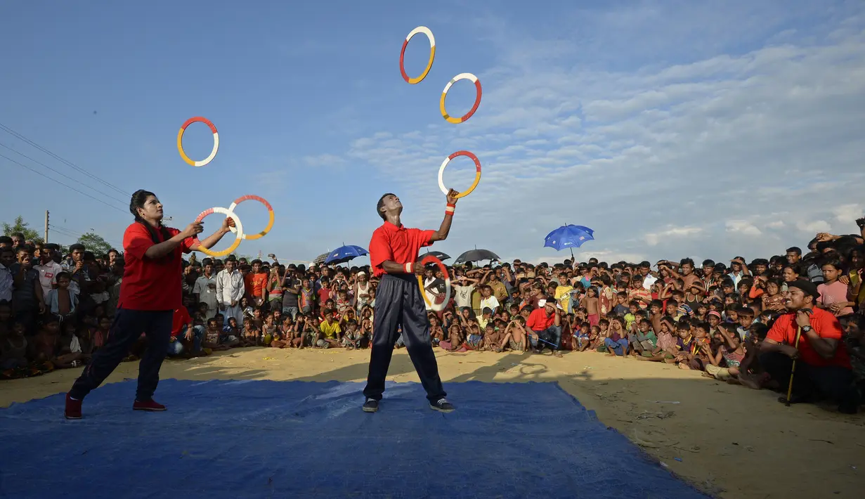 Kelompok teater Drama Therapy melakukan atraksi untuk menghibur anak-anak pengungsian Rohingya di kamp pengungsi Kutupalong, Bangladesh (28/10). (AFP Photo/Tauseef Mustafa)