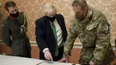 Perdana Menteri Inggris Boris Johnson (tengah) menghadiri pengarahan militer dengan Kolonel James HF Thurstan, Komandan Operasi Orbital, di Kyiv, Ukraina, Selasa (1/2/2022).  (Peter Nicholls/Pool Photo via AP)