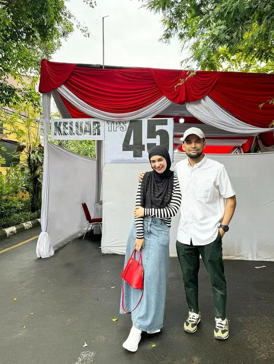 Bersama Tengku Wisnu, Shireen Sungkar nyoblos di TPS mengenakan striped long sleeve top warna hitam-putih yang dipadukan rok denim dan hand bag warna merah. [@shireensungkar]