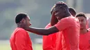 Gelandang MU, Paul Pogba berbincang dengan penyerang Memphis Depay saat mengikuti latihan di Manchester United Training Ground, Inggris, (14/9). MU akan bertanding pada laga perdana di Liga Europa melawan tim asal Belanda Feyenoord. (Reuters/Ed Sykes)