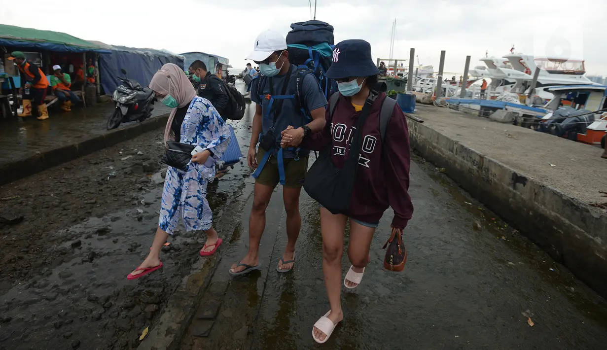 Wisatawan turun dari kapal tradisional usai perayaan malam pergantian Tahun Baru 2021 di Pelabuhan Kali Adem, Jakarta, Jumat (1/1/2021). Beberapa obyek wisata Kepulauan Seribu yang ditetapkan sebagai lokasi pengendalian ketat, adalah Pantai Sakura, Pantai Taman Arsa. (merdeka.com/Imam Buhori)