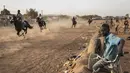 Seorang anak menonton pacuan kuda di Ouagadougou (30/1/2022). Koboi terkenal memenangkan jutaan Franc Afrika Barat dari balapan dan diam-diam melatih kuda di malam hari untuk melakukan dressage, beberapa bahkan menyebut diri mereka koboi dan berpakaian sesuai. (AFP/John Wessels)