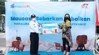 CEO Maucash Rina Apriana (kanan) menyerahkan secara simbolis penyerahan hewan kurban kepada Camat Cilandak Mundari (kiri). Pada hari raya Idul Adha 1442 Hijriyah, Maucash menyalurkan hewan kurban yang akan disalurkan kepada masyarakat sekitar kantor Maucash, Cilandak, Jakarta Selatan.