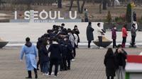 Orang-orang mengantre untuk tes virus corona di klinik skrining sementara di Seoul, Korea Selatan, Jumat (10/12/2021). Otoritas kesehatan Korea Selatan melaporkan lebih dari 7.000 kasus COVID-19 baru untuk ketiga hari berturut-turut pada hari Jumat ini. (AP Photo/Lee Jin-man)