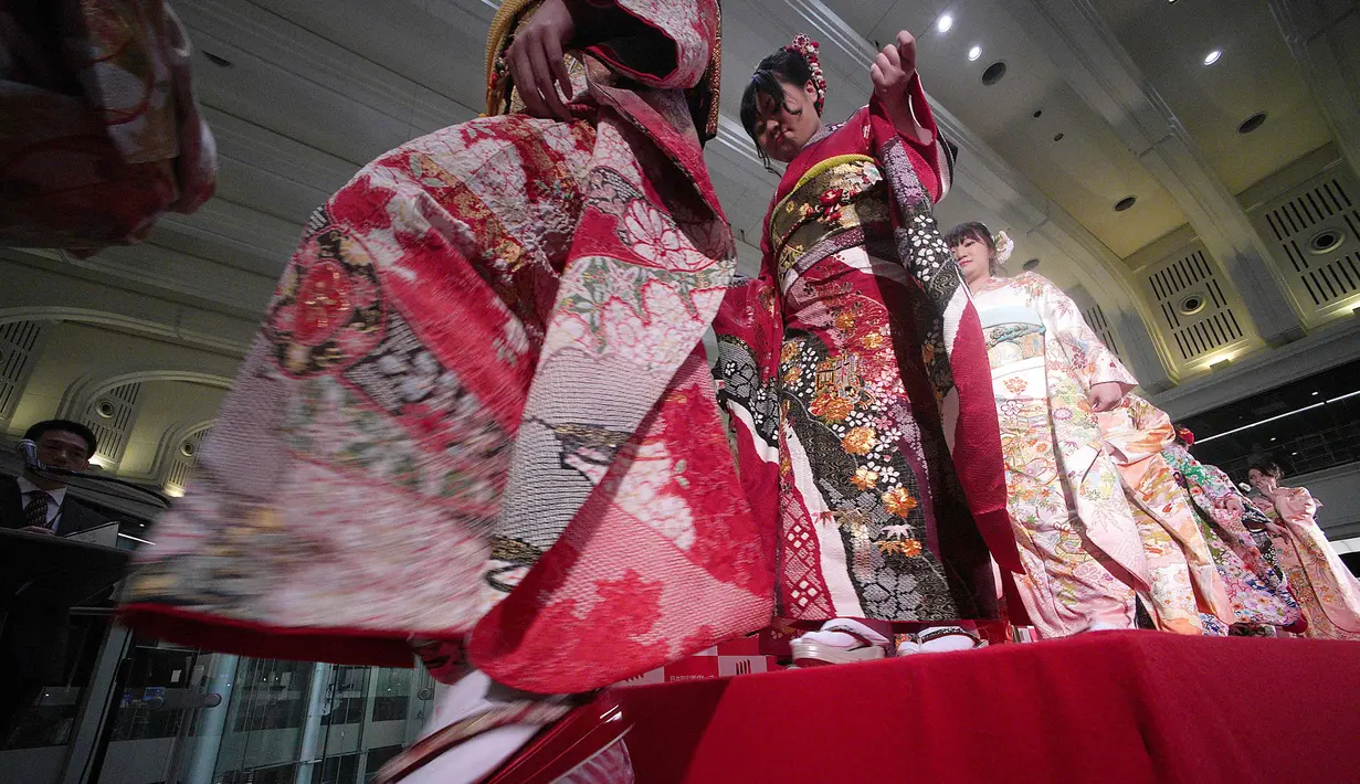 Sejumlah wanita mengenakan busana kimono setelah pembukaan pasar saham untuk tahun ini di Bursa Saham Tokyo, Jepang (4/1). Saham Tokyo melonjak pada hari pertama pembukaan pasar saham. (AP Photo/Kazuhiro Nogi)