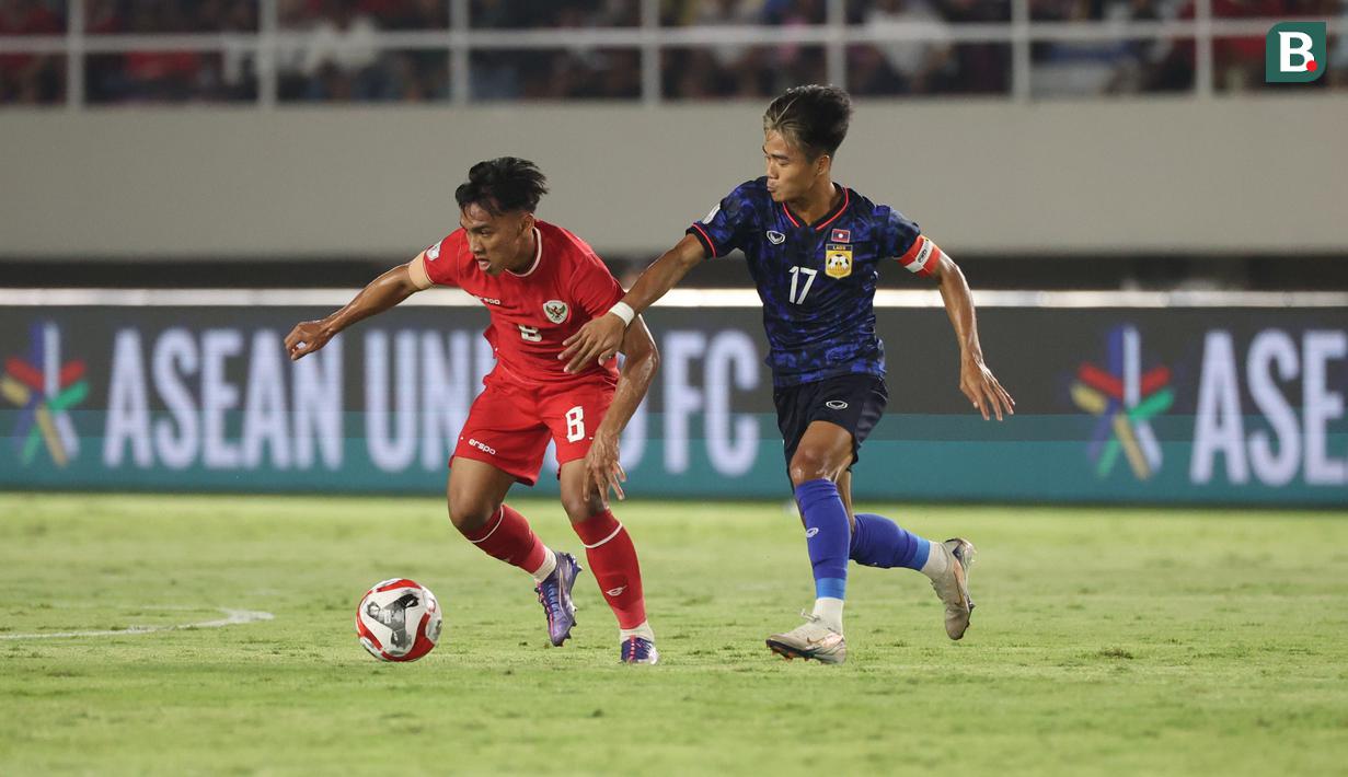 <p>Pemain Timnas Indonesia,&nbsp;Arkhan Fikri berebut bola dengan pemain Laos,&nbsp;Bounphachan Bounkong pada&nbsp;laga lanjutan Grup B Piala AFF 2024 di Stadion Manahan, Solo, Jawa Tengah, Kamis (12/12/2024). (Bola.com/Abdul Aziz)</p>