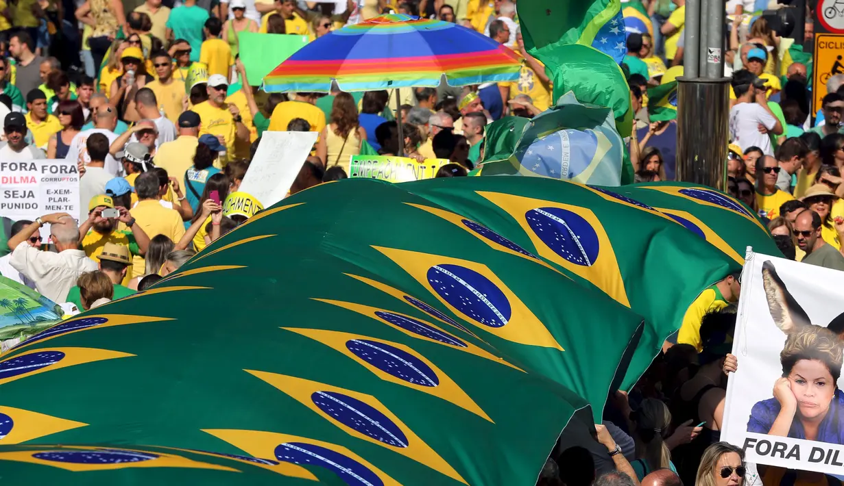 Ribuan warga membawa bendera Brazil saat protes mengecam skandal korupsi yang melanda para politisi dari partai Rousseff di Rio de Janeiro, Brasil, Minggu (16/8/2015). Mereka menuntut Dilma Rousseff untuk turun dari jabatannya. (REUTERS/Paulo Whitaker)