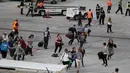 Penumpang berlarian di landasan pesawat saat penembakan di Bandara Fort Lauderdale, Florida, AS (6/1). Pelaku penembakan di bandara Florida menewaskan 5 orang. (Joe Raedle/Getty Images/AFP Photo)