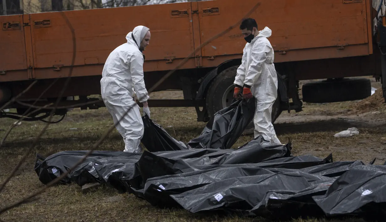 Pekerja pemakaman membawa jasad seorang pria dari kuburan massal untuk diidentifikasi di kamar mayat, di Bucha, di pinggiran Kiev, Ukraina, Minggu, 10 April 2022. Invasi Rusia ke Ukraina hingga saat ini telah berlangsung selama 46 hari.  (AP Photo/Rodrigo Abd)