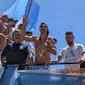 Emiliano Martinez (tengah) di parade juara Piala Dunia 2022 bareng Argentina. Dia tampak menggendong boneka bayi dengan wajah Kylian Mbappe (twitter/ori)