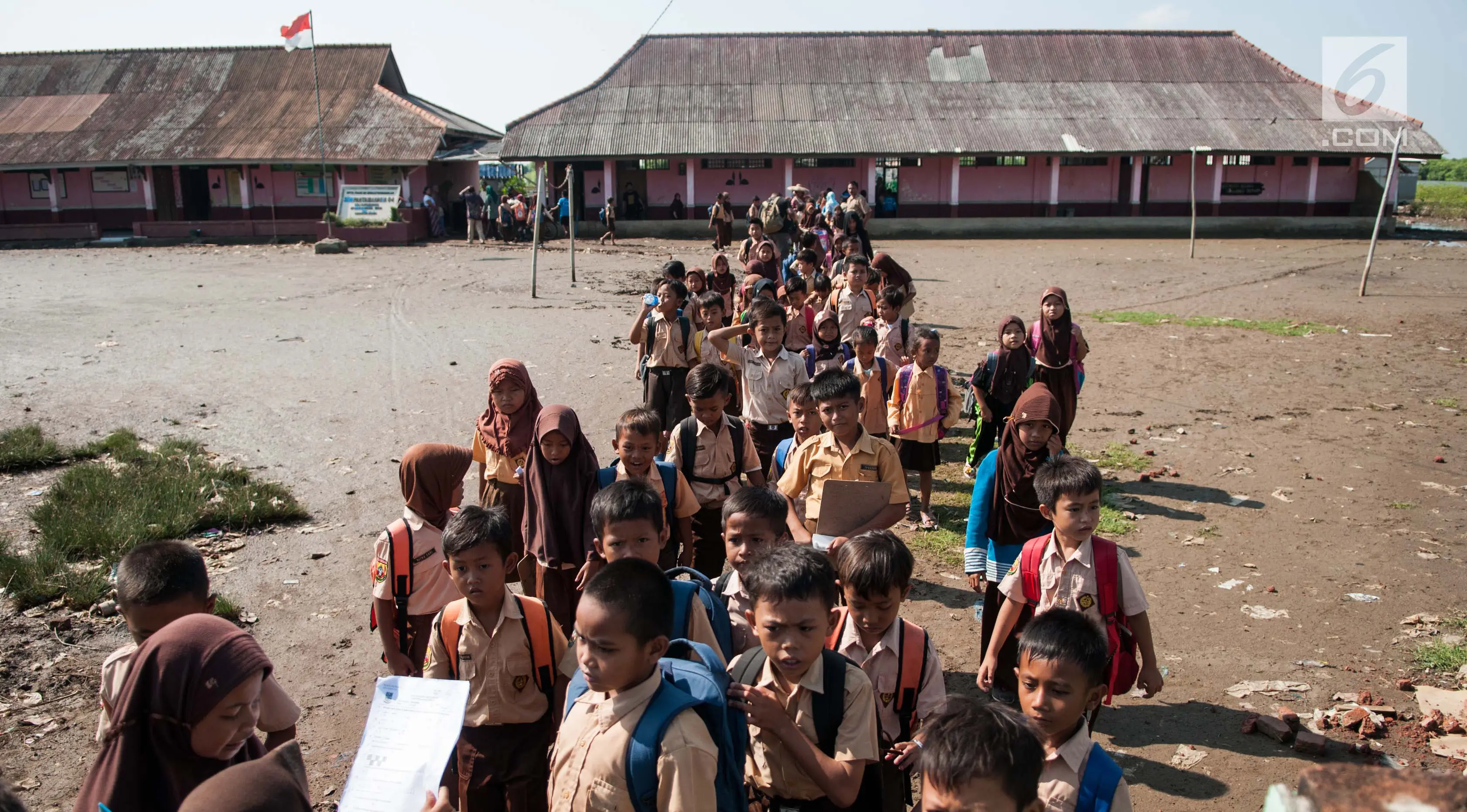 Sejumlah siswa keluar kelas usai kegiatan belajar mengajar selesai di SDN 04 Pantai Bahagia, Muara Gembong, Jawa Barat, Jumat (9/6). Banjir Rob yang sering melanda kawasan ini menyebabkan kondisi bangunan memprihatinkan. (Liputan6.com/Gempur M Surya)