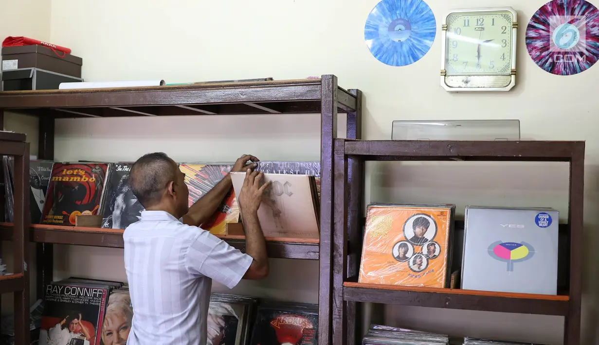 Iyan (56) merapikan piringan hitam dagangannya, Jakarta, Selasa (30/5). Piringan hitam masih menjadi daya tarik bagi penikmat musik di Tanah Air, meskipun keberadaannya harus bersaing dengan produk musik modern lainnya. (Liputan6.com/Immanuel Antonius)
