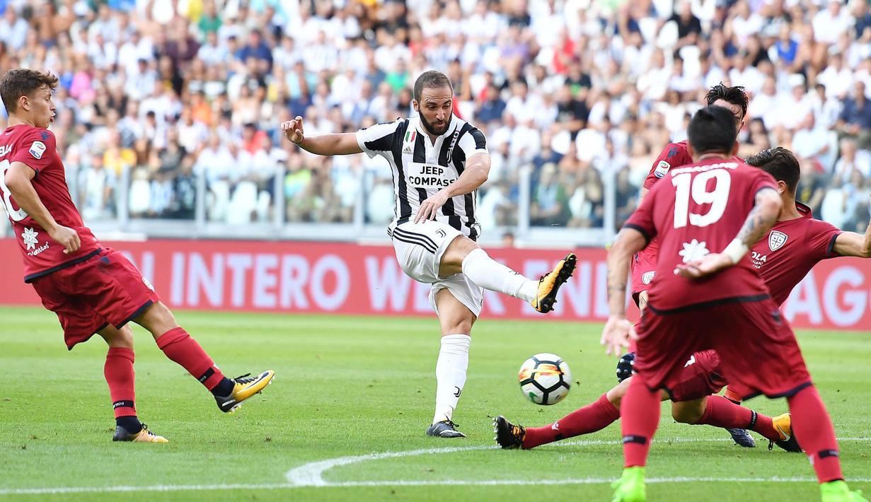 Pemain Juventus, Gonzalo Higuain melepaskan tembakan  melewati adangan pemain Cagliari pada laga Serie A di  Turin, (19/8/2017). Juventus menang 3-0. (Alessandro Di Marco/ANSA via AP)