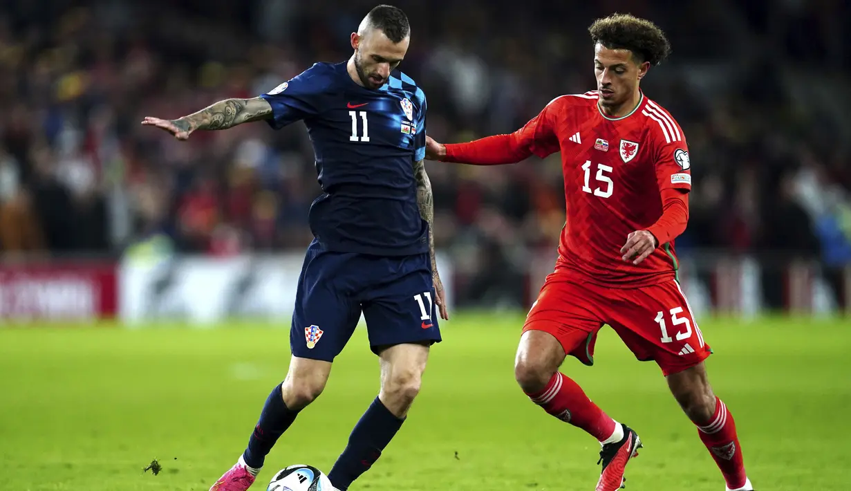 Gelandang Kroasia Marcelo Brozovic berebut bola dnegan bek Wales Ethan Ampadu pada matchday keenam Kualifikasi Euro 2024 Grup D di Stadion Kota Cardiff, Senin (16/10/2023) dini hari WIB. (Nick Potts/PA via AP)