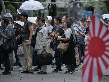 Orang-orang mengantre untuk memberikan penghormatan dan memanjatkan doa saat berkunjung ke Kuil Yasukuni di Tokyo pada Kamis 15 Agustus 2024. (Richard A. Brooks/AFP)