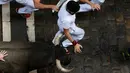 Seorang peserta terlihat menghindari serudukan banteng dalam festival San Fermin di Pamplona, Spanyol utara, (9/7). festival tahunan ini amat populer di Spanyol, dimana peserta diuji Keberaniannya dalam berhadapan dengan banteng. (REUTERS/Susana Vera)